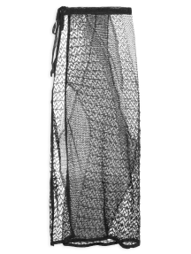 Saia longa feminina preta confeccionada em tricot vazado transparente com efeito rendado e cordão de amarração na cintura.
